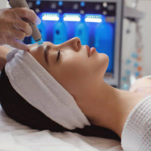 Woman receiving a facial treatment with medical equipment in the background
